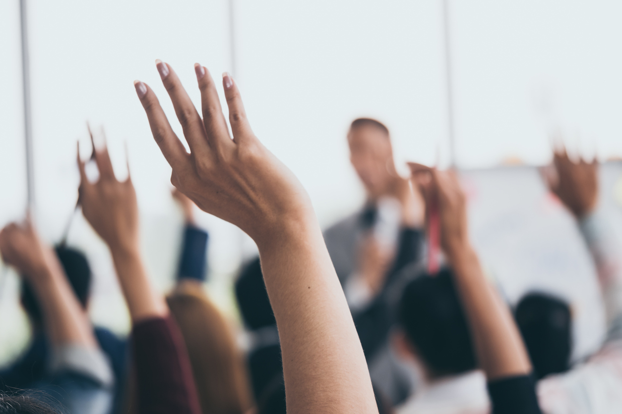 Audience raising hands to reflect students' views on teaching excellence framework