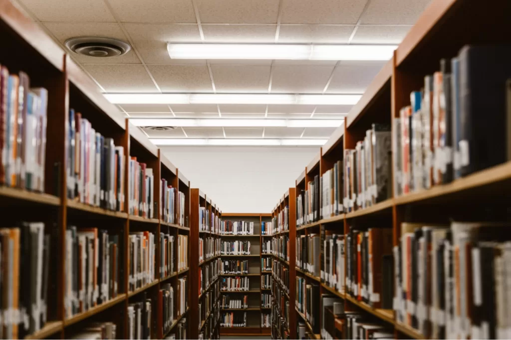 A photo of a library book stack. Within the photo, there are bookshelves on either side.