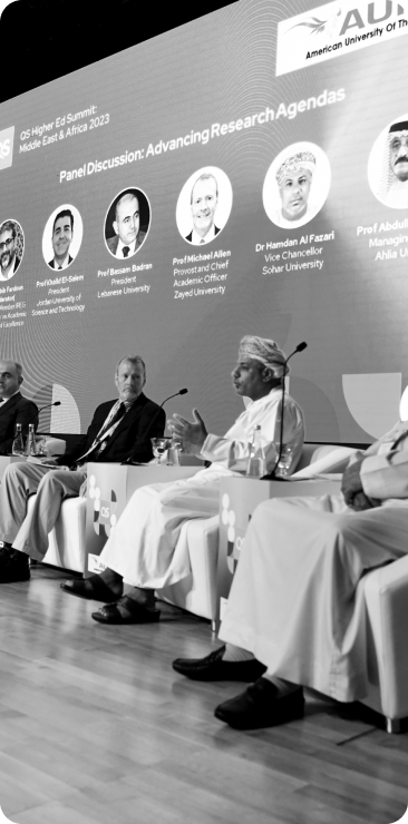 A black and white photo of a group of panellists presenting at a conference.