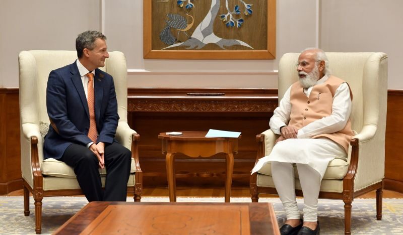 A photo of Nunizo Quacquarelli sitting in a chair and smiling whilst having a conversation with India’s Prime Minister Narendra Modi.