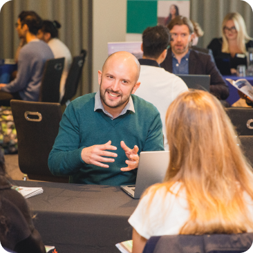 A representative to a prospective student sat across a table from them at a student recruitment event.