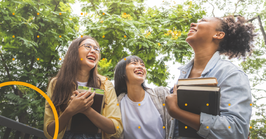 An image of three students underneath a leafy tree